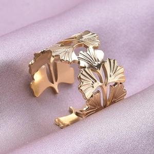 Macro d'une bague feuille de ginkgo dorée avec détails ajourés sur soie mauve