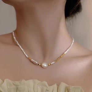 Detailed shot of Baroque irregular pearl necklace with gold square beads on a model's neck