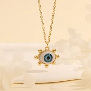 Detailed view of evil eye necklace with blue pupil and 18K gold plated chain on white stand