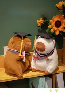 Close-up of brown and white capybara plushies in graduation caps on a shelf