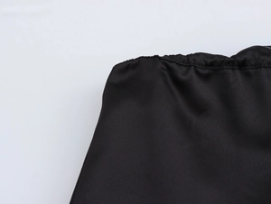 Detail of the elastic waistband on a glossy black silk satin bubble mini skirt