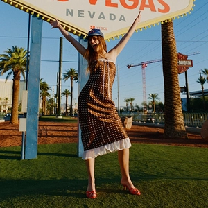 Polka dot satin midi dress with ruffle hem shown in a bright outdoor Vegas setting