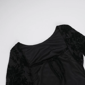 Macro shot of back neckline with ties and black velvet floral pattern on mesh fabric