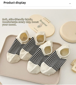 Close-up of four pairs of beige striped low-cut cotton socks on a display tray