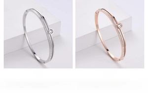 Detail view of steel and rose gold double-layer bangles with cubic zirconia inlay
