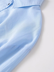 Detalle del cuello de camisa azul claro con botones y textura de tela de alta calidad