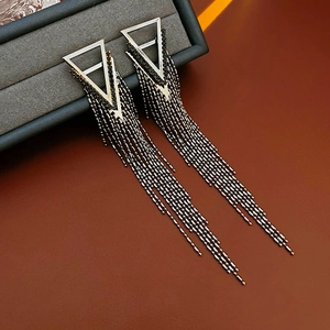 Detail of dark metal triangle tassel earrings with crystals in a luxury jewelry box
