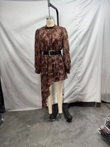 Dettaglio dell'abito in chiffon marrone stampato con cintura e orlo asimmetrico