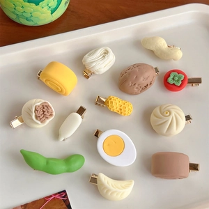 Detailed top view of 12 realistic food-shaped hair clips like steamed buns and eggs on a tray