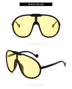 Close-up of black oversized aviator sunglasses with vibrant yellow transparent lenses