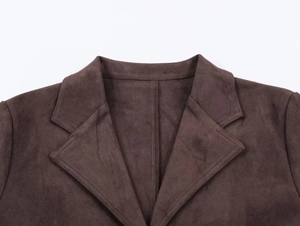 Detailed close-up of a dark brown suede-effect jacket lapel and collar on white background