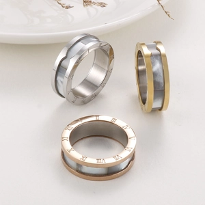 Macro view of Roman numerals and shell inlay on steel rings in gold and silver