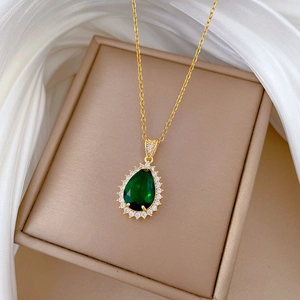 Close-up of a pear-shaped green zircon pendant with pavé crystals on gold chain