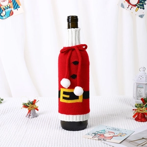 Knitted red Christmas wine bottle cover with Santa belt design and white pom-poms