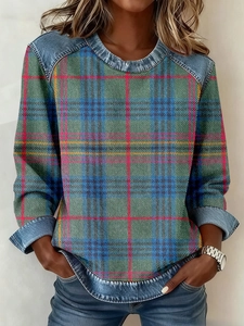 Detail of knitted plaid pattern sweater with denim patchwork on shoulders and cuffs