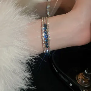 Macro shot of sparkling triple-row zircon bracelet with blue sapphire stones and white diamonds