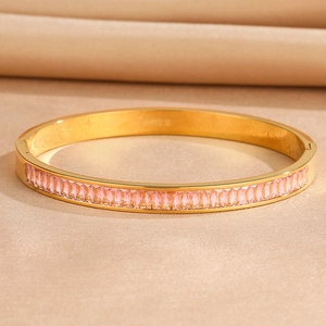 Detail of gold stainless steel hinge bangle with pink rectangular zircon inlay