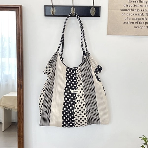 Détail de la poignée en corde tressée et des motifs à pois sur un grand sac en toile
