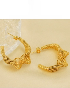Close-up of golden stainless steel twisted spring earrings with irregular wave design