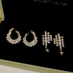 Detailed shot of pearl and zircon star drop earrings on a black velvet jewelry box