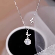 Detail of s925 silver necklace with butterfly charm and translucent white bead pendant