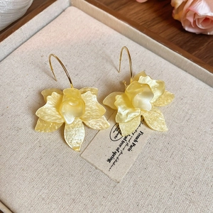 Detailed view of yellow flower acrylic earrings with golden hooks and resin texture