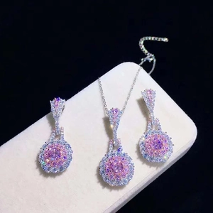 Macro view of pink crystal jewelry set featuring circular halo pendant and matching earrings
