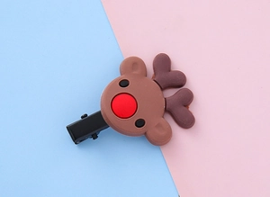 Gros plan d'une pince à cheveux renne de Noël marron avec nez rouge sur fond bicolore