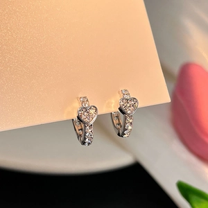 Vue macro de boucles d'oreilles cœur en argent avec incrustations de zircone