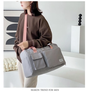 Gray fitness bag with pink straps showing front multi-pocket storage and nylon texture