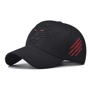 Detailed close-up of tiger head embroidery and red claw marks on black cotton baseball cap