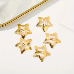 Set of five 3cm golden star-shaped metal hair clips in a radial layout on white background