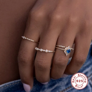 S925 sterling silver stackable ring set with pearls and blue crystal on denim background