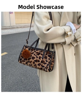 Detail of leopard print faux fur handbag with leather handle and plush ball charm