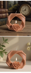 Candela artistica ad anello cannella con rosa centrale su una pila di libri d'epoca