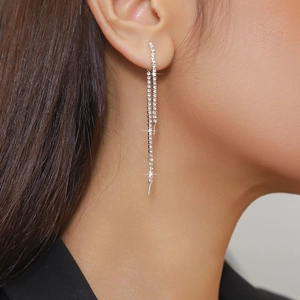 Detail of elegant silver long tassel earrings with sparkling rhinestones on model