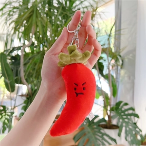 Close-up of a plush red chili pepper keychain with CE safety label and metal ring