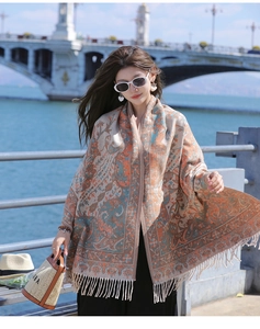 Detail of vintage paisley pattern shawl with fringe on a sunny seaside bridge