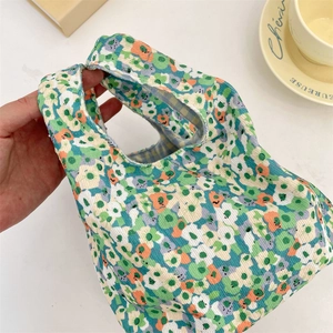 Detail of floral corduroy wrist bag with soft fabric texture and integrated handle