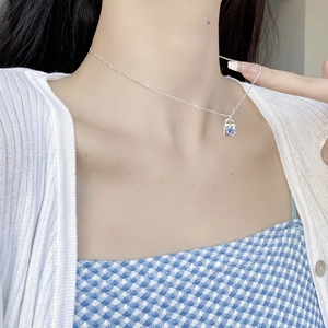 Elegant silver padlock necklace with blue zircon heart pendant worn by a model
