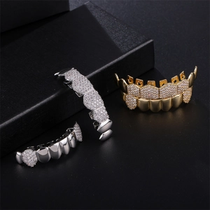 Hip hop grillz set with sparkling rhinestones in gold and silver plating on black background