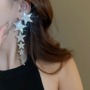 Macro detail of silver needle tassel earrings featuring cascading sparkling star elements