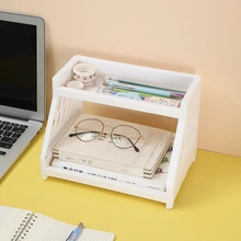 Close-up of a white two-tier desktop storage rack organizing books and office stationery