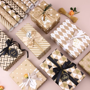 Elegant gold and black gift wrapping paper set with ribbons and tags for birthdays