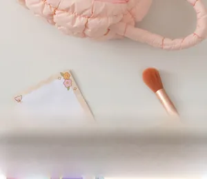 Detailed view of pink quilted puffer cosmetic bag with soft padded handle and texture