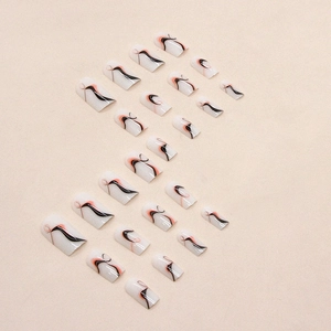 Abstract wavy stripe press-on nails set with orange and black swirl art on milky base
