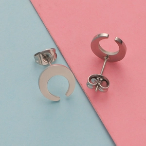 Minimalist silver stainless steel crescent moon stud earrings on a colorful background