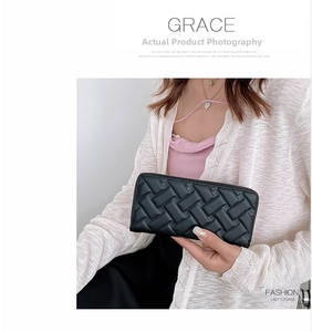 Detail of hand-held black woven leather long wallet with zipper closure for women