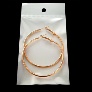 Detailed view of large rose gold thin hoop earrings in minimalist circular style