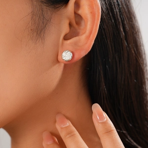Detail of silver twisted knot stud earring on model showing metallic woven texture